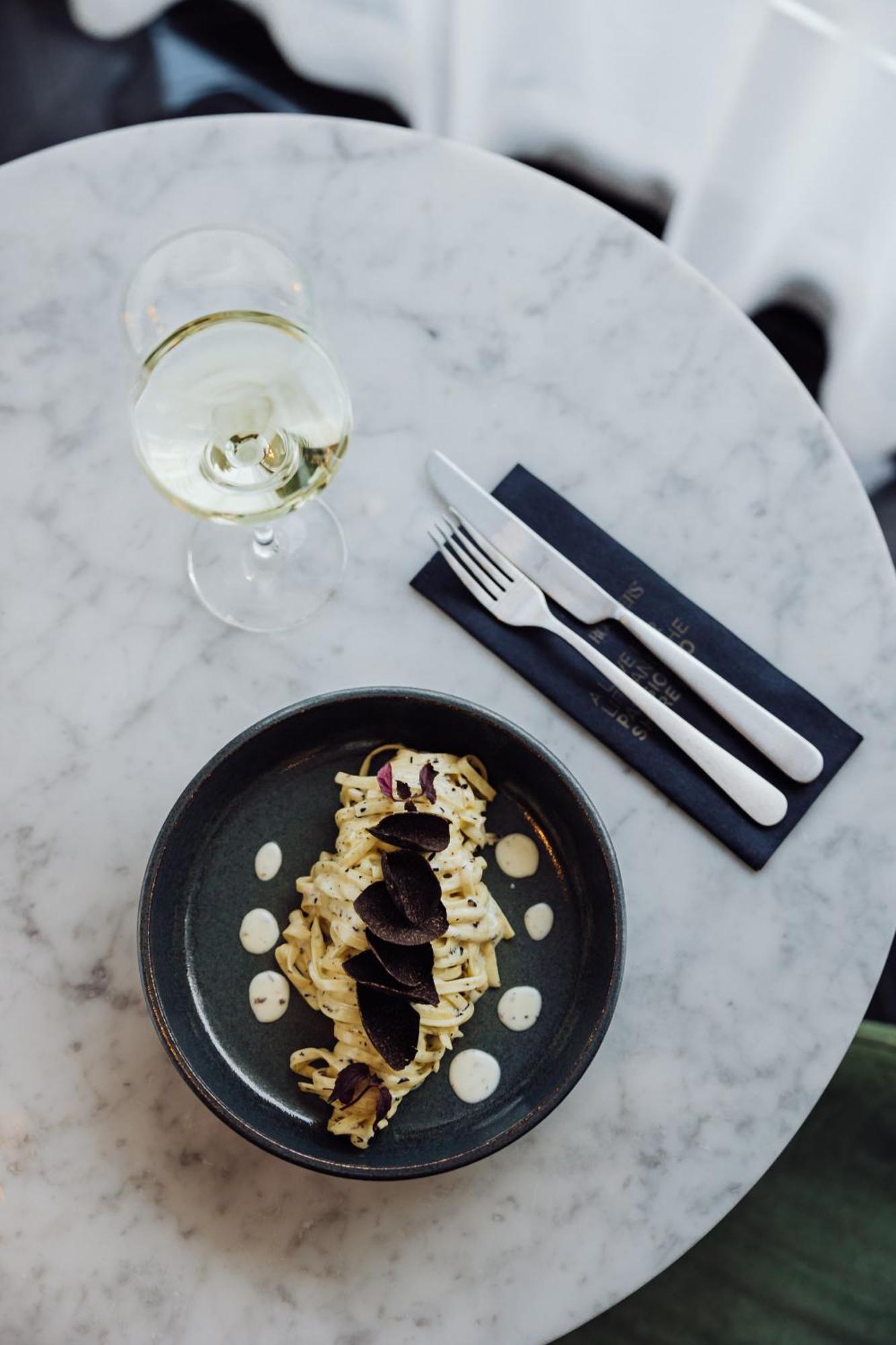 Roomers Munich, Autograph Collection Bagian luar foto A place setting with a wine glass, a fork and a knife