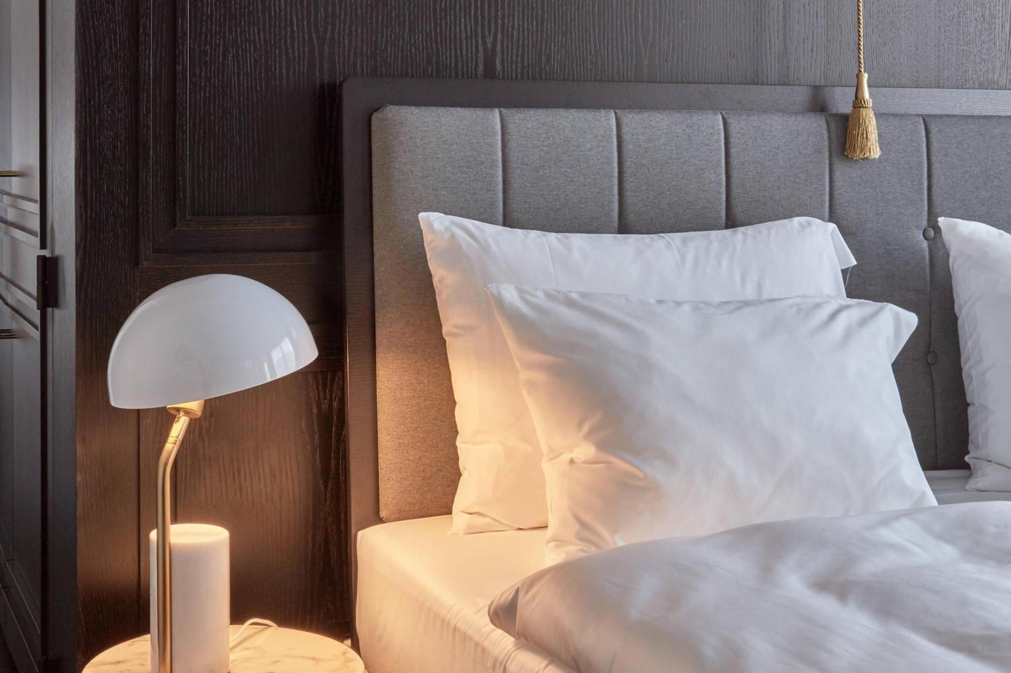 Roomers Munich, Autograph Collection Bagian luar foto A bed with pillows